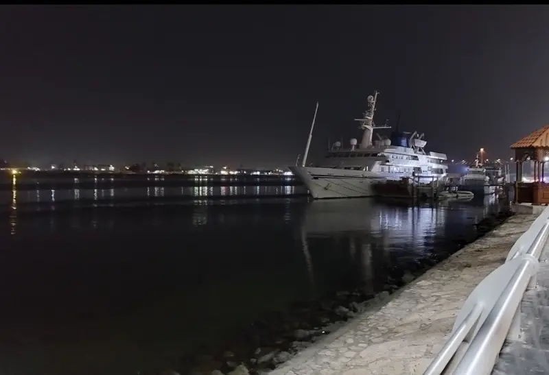 The Basra corniche at night, a vessel moored along the embankment