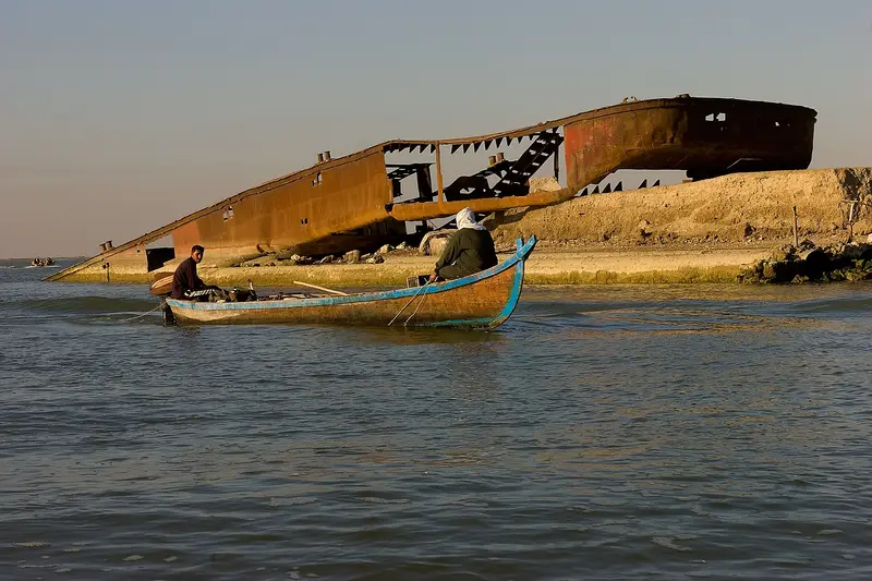A mashoof canoe loaded with cut reeds in the marshes