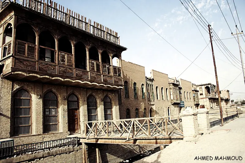 A carved wooden shanasheel balcony overhanging a street in old Basra